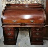 A Victorian mahogany roll top desk, the cylinder top with brass handles opening to reveal a pull out