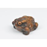 A Japanese wooden carved netsuke modelled as a crouching toad, Edo period, signed to the underside