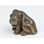 A Japanese finely carved wood netsuke, 19th century, modelled as a snarling tiger, with ivory