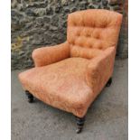 A Victorian walnut and upholstered Howard style armchair, the buttoned back seat upholstered with