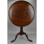 A Georgian mahogany occasional table, the tilt top of circular form with moulded border, above a