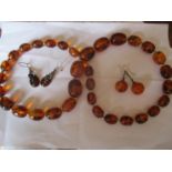 An amber necklace with 33 amber beads separated by a gold tone bead together with two pairs of white