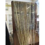 An 8ft brass curtain pole and accessories, together with two modern plastic bead door curtains,
