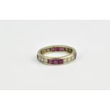 A white metal, diamond and ruby full eternity ring, with channel set rubbies in sets of three