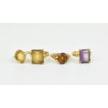 A group of four gem set dress rings, comprising amethyst, citrine, and two other gemstones, possibly