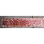 A Turkish tribal hand woven runner, with repetitive motif along the centre and geometrical