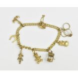 A 9ct yellow gold thin curb link charm bracelet with various charms to include an articulated