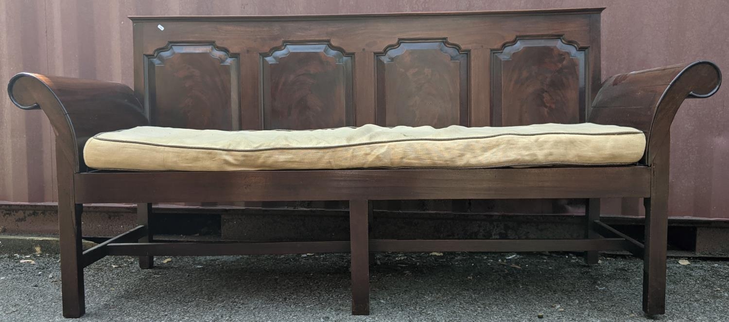 A George III mahogany settle/bench with scroll ends and panelled back with four moulded panels,