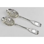 A pair of Victorian silver berry spoons, London 1889, with embossed flowers to the bowls and further