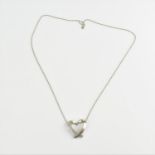 A diamond encrusted 18ct white gold heart shaped pendant on an 18ct gold chain, the pendant 2.2 cm