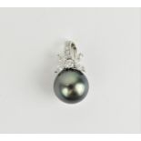 An 18ct white gold, diamond and Tahitian pearl pendant, the pearl surmounted with a diamond floral