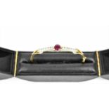 An 18ct yellow gold, ruby and and diamond bangle, with central cut ruby flanked by a row of seven