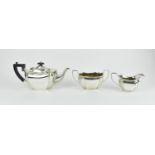 A late Edwardian silver three piece tea set, Birmingham 1910, comprising a teapot with ebony