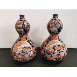 A pair of early 20th century Japanese porcelain double gourd vases in the Imari pallet, 25cm h