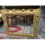 A late 19th/early 20th century carved gilt wood mirror with later glass plate, 85 x 98cm