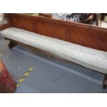 A pitch pine pew with green cushion 92cm h x x 236cm w x 48cm d Location: Back Row