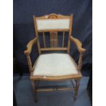 A late Victorian, early Edwardian, walnut salon chair with a floral cream head rest and seat