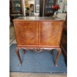 A reproduction mahogany drinks cabinet, inlaid glass top, twin burr walnut veneered doors,