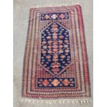 A Northeast Persian Mashad Belouch rug with geometric design on a cobalt blue ground, contained by