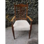 An oak arts and crafts open armchair with central pierced centre splat, upholstered seat on shaped