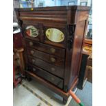 A Victorian chest of four long drawers having a frieze drawer and a pair of mirrored, panelled