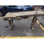 A late 19th century/early 20th century wooden woodwork bench with a vice at either end on trestle