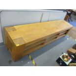 A modern light oak low unit having six open shelves and block shaped feet 50cm h x 220cm w