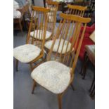 A set of four Ercol beech dining chairs with blue labels and spindle backs on turned legs