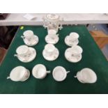 A French porcelain part tea set comprising of ten cups, six saucers and twin handled pot (possibly