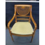 A modern cane chair Empire style with upholstered seat with fleur de lye pattern