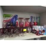 A collection of decorative glass to include ruby red pedestal wine glasses and three art glass