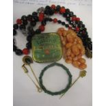 A small lot comprising a green glass bracelet in the style of Jade, and two yellow coloured hat/