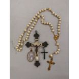 A yellow metal and ivory beaded necklace with yellow metal cross pendant, a yellow metal and