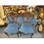 A set of five late Victorian walnut dining chairs with carved ornament, the seats upholstered in a