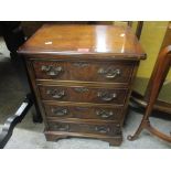 A reproduction walnut low chest of four drawers on bracket shaped feet 61cm h x 45cm w