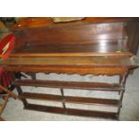 A Georgian oak dresser, the top with three open back plate shelves, above a base with 3/4 gallery