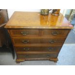 A late 20th century reproduction of a George III walnut and feather banded chest of two short and
