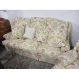 A Parker Knoll two-piece suite upholstered in a floral fabric comprising a three-person settee and