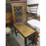 An oak glazed wall hanging corner cabinet, together with an oak side table having carved decoration