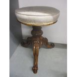 A late Victorian walnut piano stool with a rotating, height adjustable seat, over a carved column,