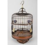 A 20th century Chinese wooden and cane bird cage with a metal hook, a jade and bone finial, bone