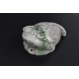 A Chinese mottled green jade model of a toad, with detail to the back and pierced hole to the