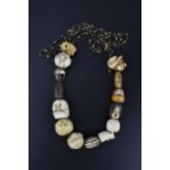 A 19th century Japanese ojime bead necklace, with carved ivory, bone, and metal ojimes, modelled