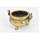 A Chinese bronze tripod censer, with lotus shaped base and curved twin handles, the underside with