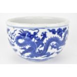 A 19th century Chinese blue and white planter with curved sides decorated with two dragons, clouds