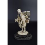 A Japanese Meiji period ivory okimono of a pedlar, well carved with his wares, woven baskets and