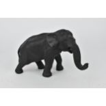 A Japanese Meiji period patinated bronze model of an elephant, realistically rendered with