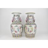 A pair of late 19th century Cantonese famille rose vases, of baluster shape with applied