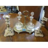 Two glass decanters on a silver plated stand, together with a pair of silver plated candlesticks