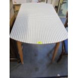 A vintage folding kitchen table with chequered Formica top above light wooden legs Location: RAM